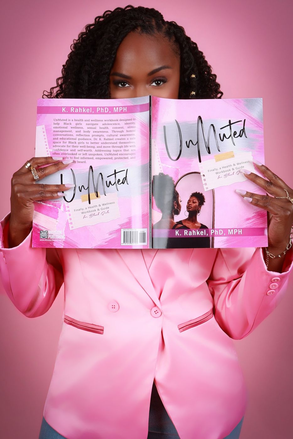 Dr. K. Rahkel holding the UnMuted workbook open in front of her face